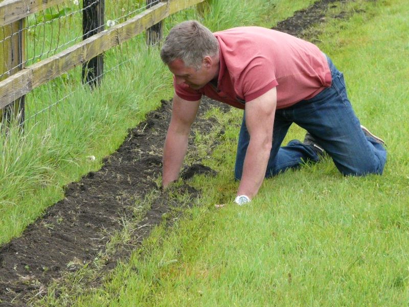 Jason Stephens removing large stones from  trench